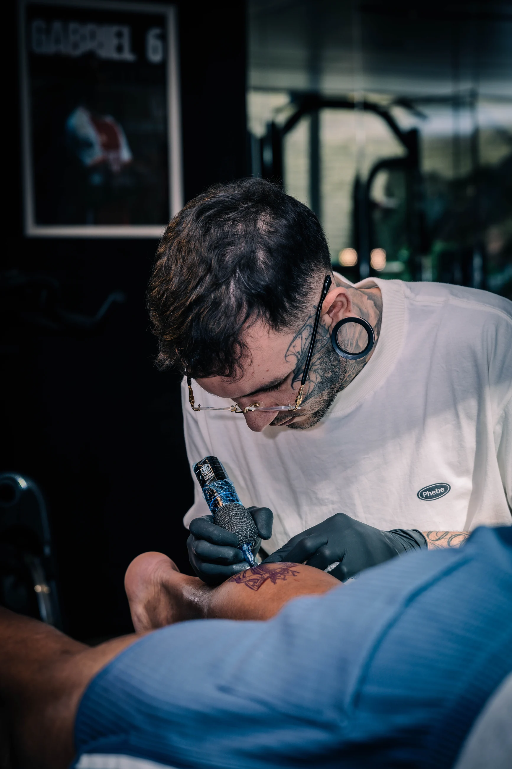 Artist Diego Santos tattooing Gabriel Magalhães