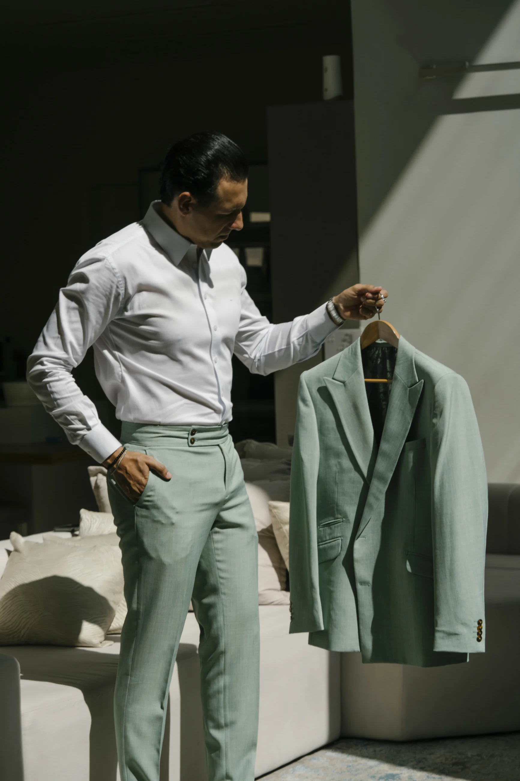 Model considering a pale green Lapela suit in directional sunlight